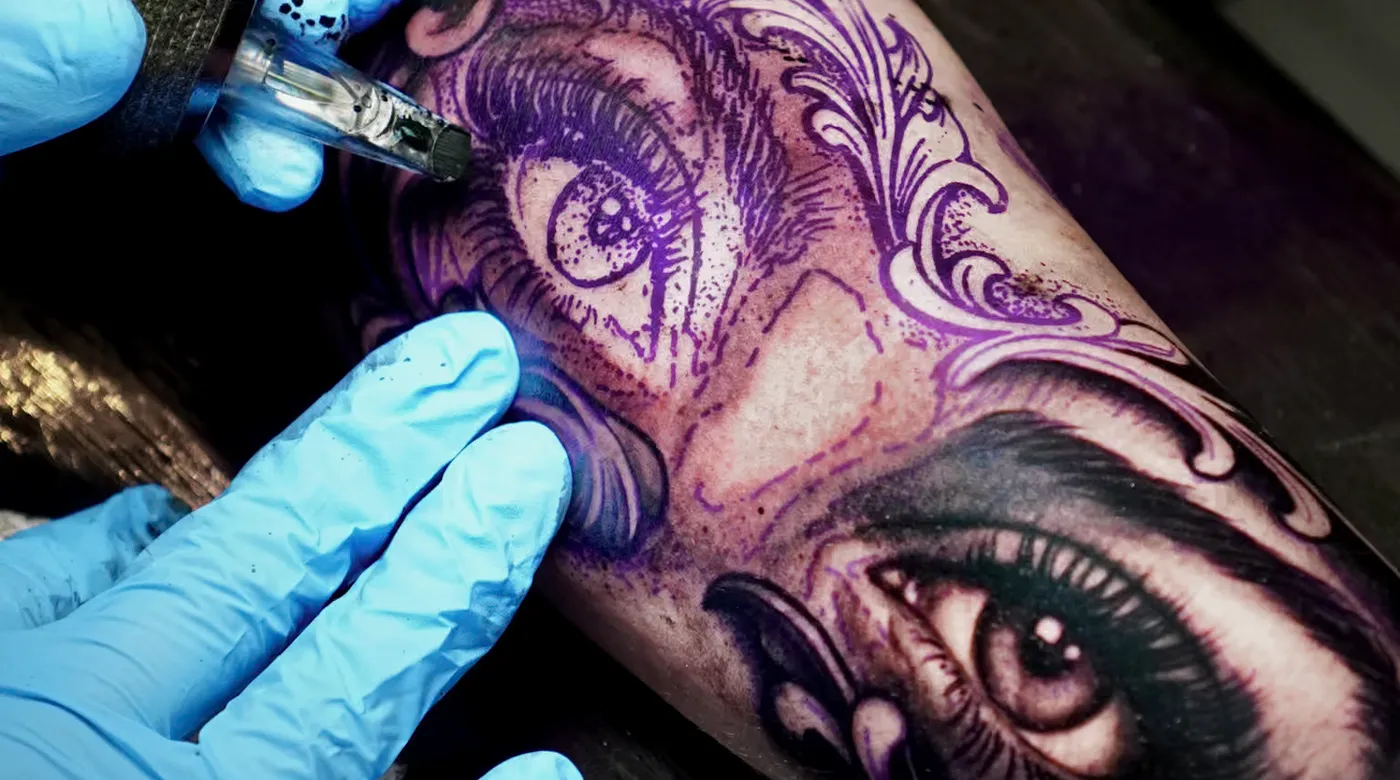 Clayton Goethe tattooing a realistic eye detail in black and grey realism style