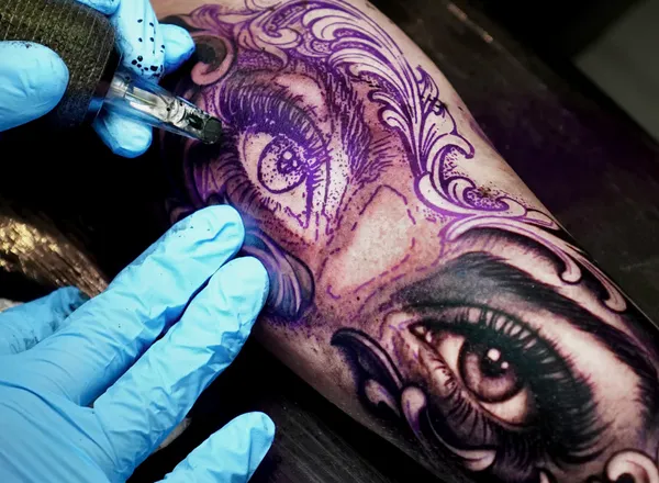 Clayton Goethe tattooing a realistic eye detail in black and grey realism style