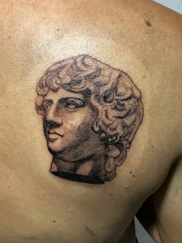Tatuaje de escultura griega en espalda por Clayton Goethe