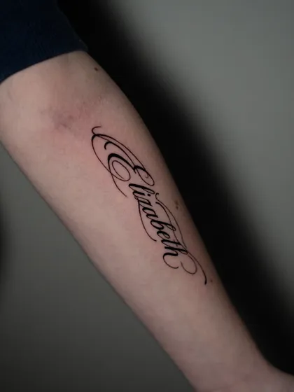 Tatuaje minimalista con lettering elegante en antebrazo por Goethe Ink Barranquilla